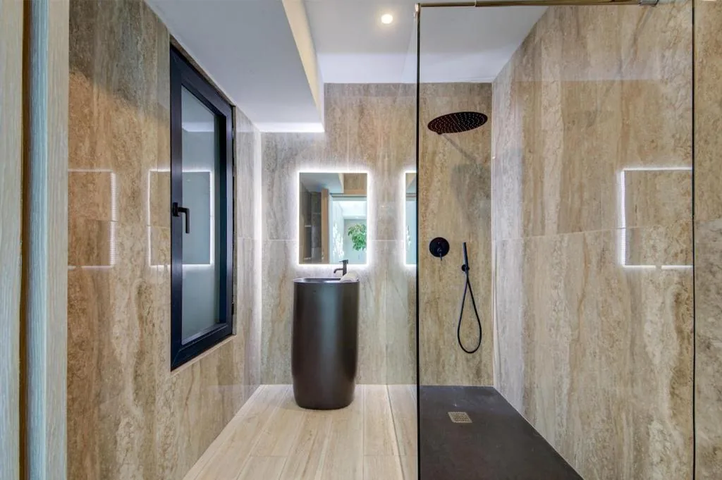A travertine bathroom with a rain shower